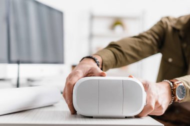 Masadan sanal gerçeklik kulaklığı alan 3D sanatçının kırpılmış görüntüsü 