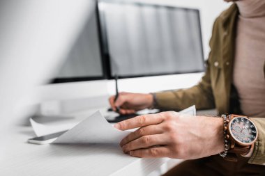 Selective focus of 3d artist using blueprint while working with graphics tablet and computers  clipart