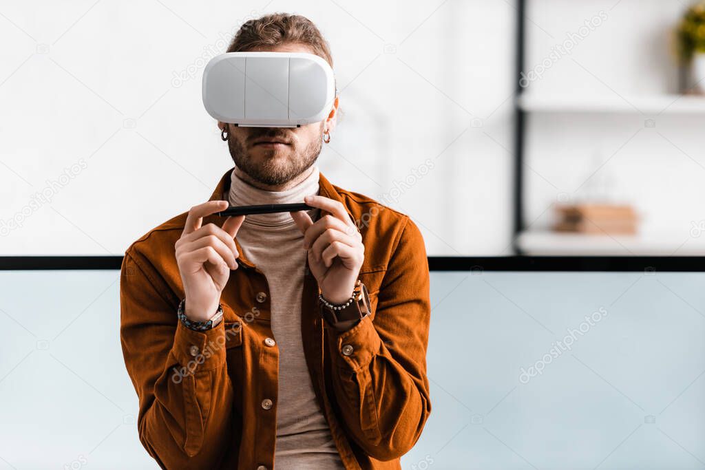 3d visualizer using virtual reality headset and holding stylus of graphics tablet near computer monitors in office 