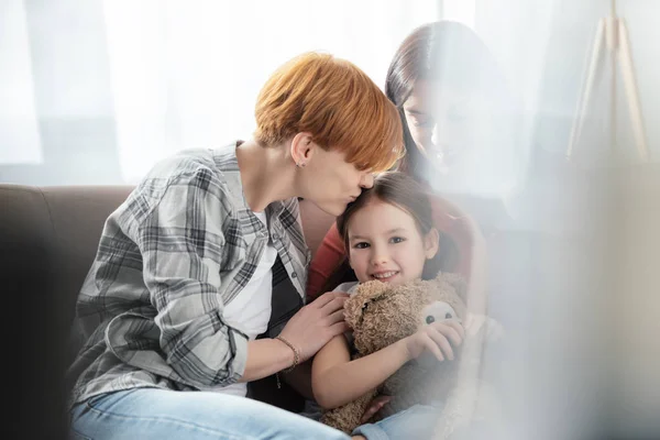 Selective Focus Mother Kissing Daughter Teddy Bear Looking Camera Parent — Stock Photo, Image