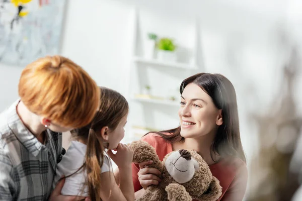 Enfoque Selectivo Madre Sonriente Sosteniendo Oso Peluche Cerca Hija Padre — Foto de Stock