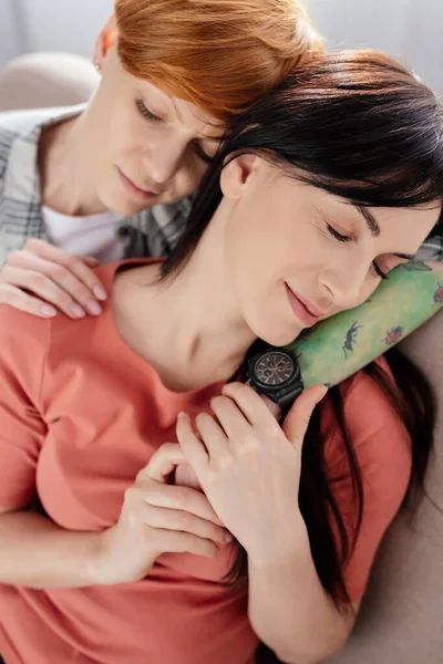 Same Sex Couple Closed Eyes Holding Hands Embracing Sofa Grey — Stock Photo, Image