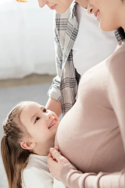 Boční Pohled Usmívající Dítě Dotýká Břicha Těhotné Matky Doma — Stock fotografie