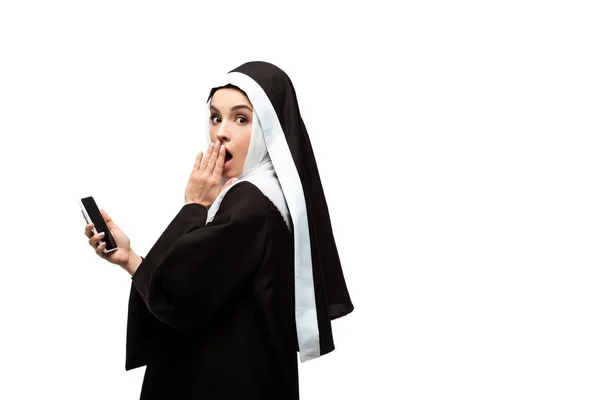 漂亮惊讶的修女使用智能手机隔离在白色 — 图库照片