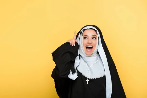 Schöne Aufgeregte Nonne Zeigt Nach Oben Auf Gelb — Stockfoto