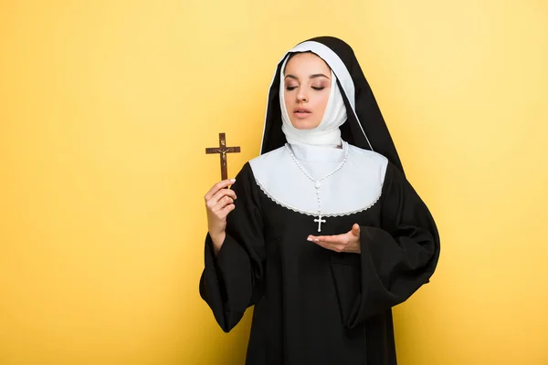 Schöne Junge Nonne Zeigt Kreuz Auf Gelb — Stockfoto