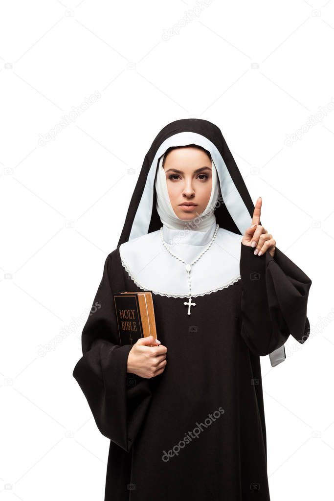 beautiful nun holding bible and pointing up with idea isolated on white