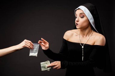 thoughtful nun with money buying plastic bag of cocaine isolated on grey clipart