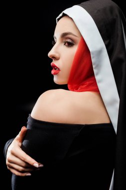 Siyah elbise ve kırmızı eşarp giymiş, siyah üzerine izole edilmiş güzel seksi rahibe.