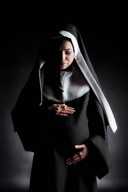 upset pregnant nun touching belly on grey clipart