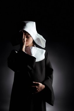 upset tired pregnant nun with closed eyes standing on grey clipart