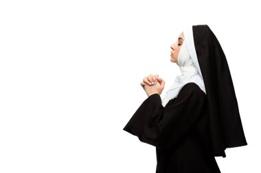 attractive nun praying with closed eyes and hands together isolated on white clipart