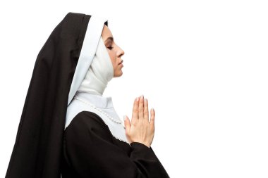 attractive nun praying with closed eyes and hands together isolated on white clipart