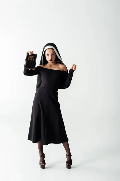 Gri Üzerinde Ncil Tutan Siyah Elbiseli Güzel Seksi Rahibe — Stok fotoğraf