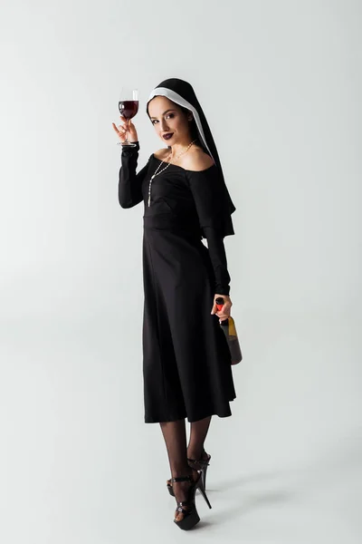 Attraktive Sexy Nonne Mit Glas Und Flasche Wein Auf Grau — Stockfoto