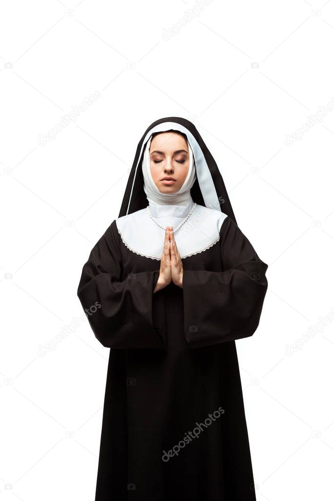 nun praying with closed eyes and hands together isolated on white