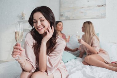 Gözleri kapalı esmer kızın seçici odağı gülümseyen ve çok ırklı arkadaşlarıyla şampanya bardağı tutan