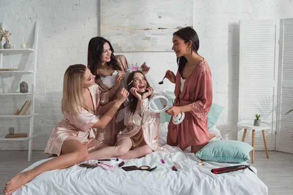 在单身派对上 多文化女性在床上化妆 — 图库照片