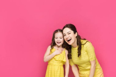 Mutlu anne-kız gülüşleri pembe üzerine izole. 