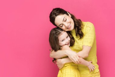 Neşeli anne-kız kucaklaşması pembe renkte. 