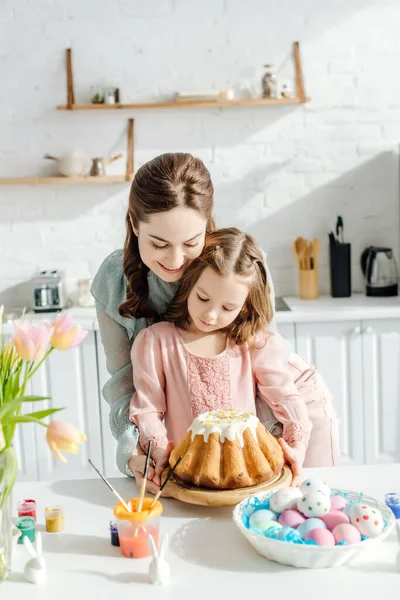 Madre Atractiva Feliz Niño Cerca Huevos Pascua Conejos Decorativos Pan —  Fotos de Stock