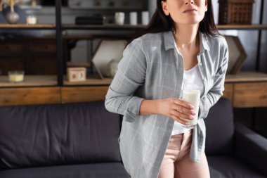 cropped view of woman with lactose intolerance holding glass of milk  clipart