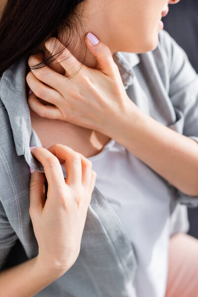 cropped view of allergic woman scratching neck 