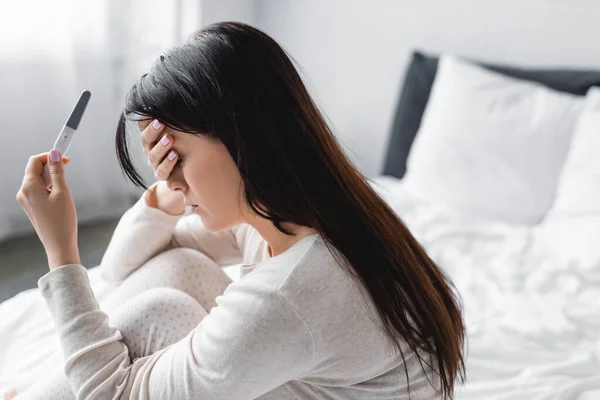 Besviken Kvinna Som Håller Graviditetstest Med Negativt Resultat Sovrummet — Stockfoto