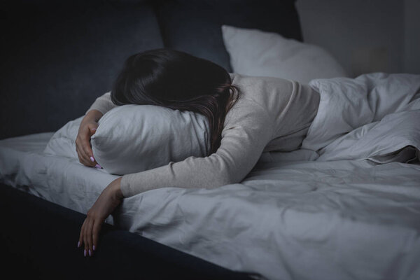 бодрствующая женщина, страдающая бессонницей и лежащая на подушке ночью
 