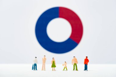 Selective focus of row of people figures on white surface with diagram at background, concept of inequality clipart
