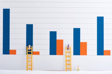 People figures with ladders on white surface with charts at background, equality concept clipart