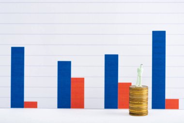 İnsanlar altın sikkeler üzerinde beyaz yüzeyde arka planda mavi ve kırmızı grafikler, finansal eşitlik kavramı