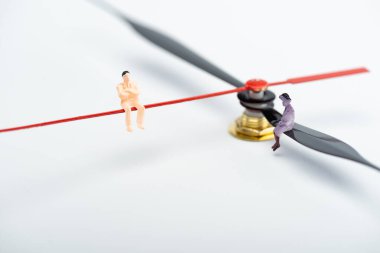 Plastik insan figürlerinin beyaz yüzeydeki saat işaretleri, yaşlanma konsepti üzerindeki görüntülerini kapat