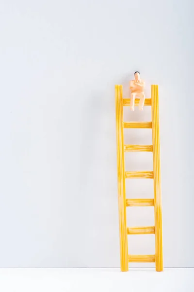 Vista Perto Boneca Escada Superfície Branca Sobre Fundo Cinza Conceito — Fotografia de Stock