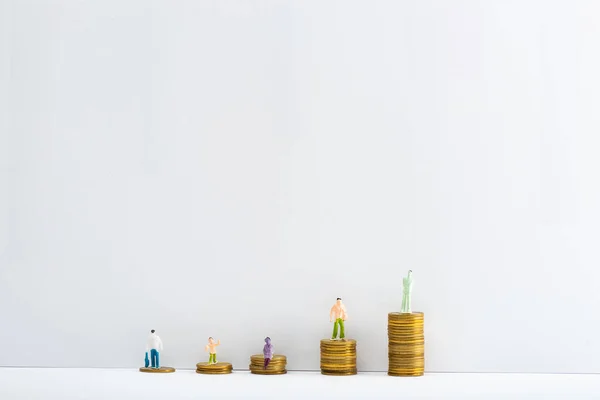 Figuras Plástico Sobre Monedas Apiladas Sobre Superficie Blanca Sobre Fondo — Foto de Stock