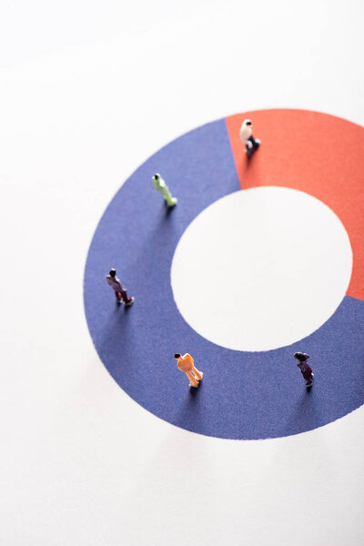 High angle view of people figures on red and blue round diagram on white surface, concept of disparity