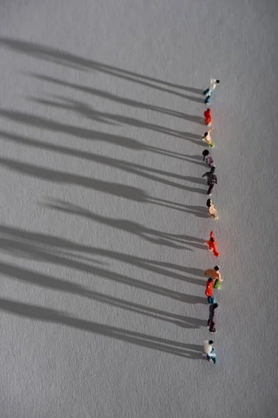 Top View Row Plastic People Figures Shadow Gray Surface — Stock Photo, Image