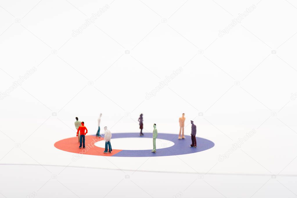 Toy people figures on diagram on white surface isolated on white, concept of disparity