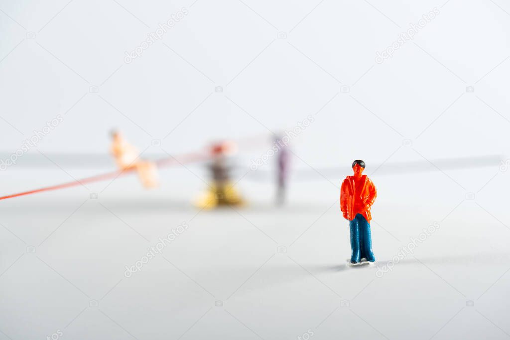 Selective focus of people figure near dolls and arrows of clock on white surface, concept of senescence
