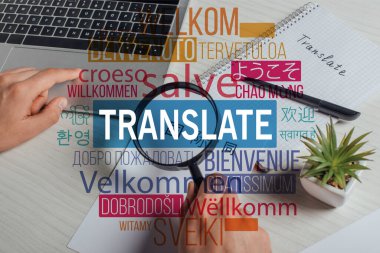 cropped view of translator working with hieroglyphics, laptop and magnifying glass, welcome translation illustration clipart
