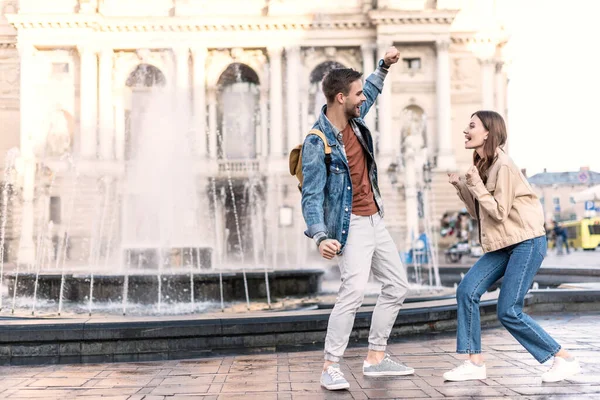 興奮した女性と男は市内の噴水の近くでお互いを見て — ストック写真
