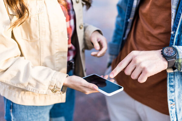 Cropped view of couple using smartphone