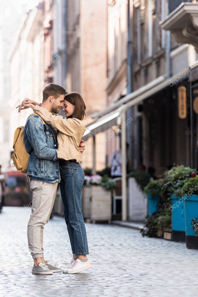 Happy boyfriend and girlfriend hugging in city