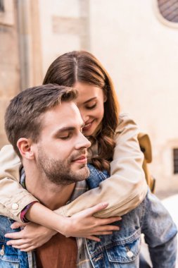 Selective focus of girlfriend hugging boyfriend with closed eyes clipart