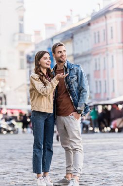 Boyfriend and girlfriend looking away and smiling in city clipart