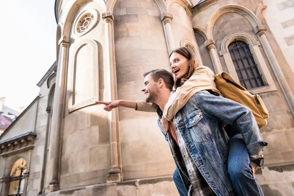 Low Angle View Man Piggybacking Girlfriend Pointing Finger Building City — Stock Photo, Image