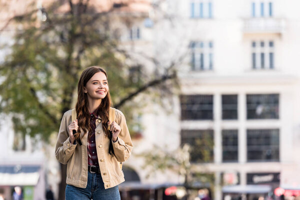Beautiful woman smiling with backpack in city