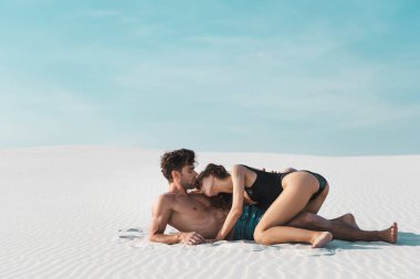 Sanddy Beach 'te erkek arkadaş üzerinde seksi genç bir kadının yan görüntüsü