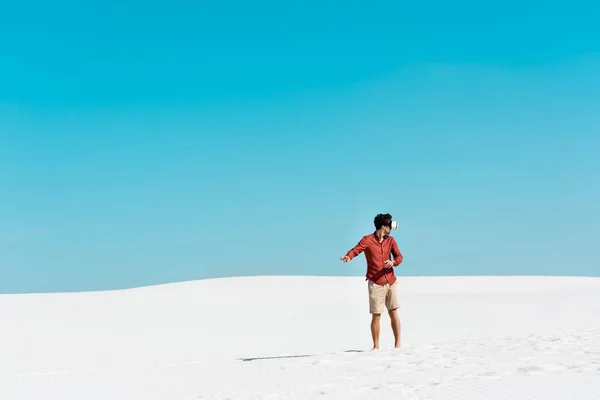 Man Zandstrand Headset Gebaar Tegen Heldere Blauwe Lucht — Stockfoto