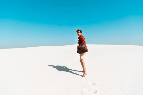 Pohledný Muž Koženou Taškou Písečné Pláži Stopami — Stock fotografie